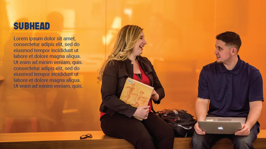 Two students on a bench against a yellow-orange background, with a book and a laptop.