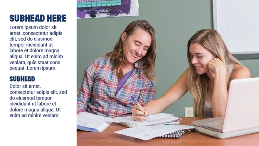 Two smiling young women study together at a table with notebooks and a laptop.