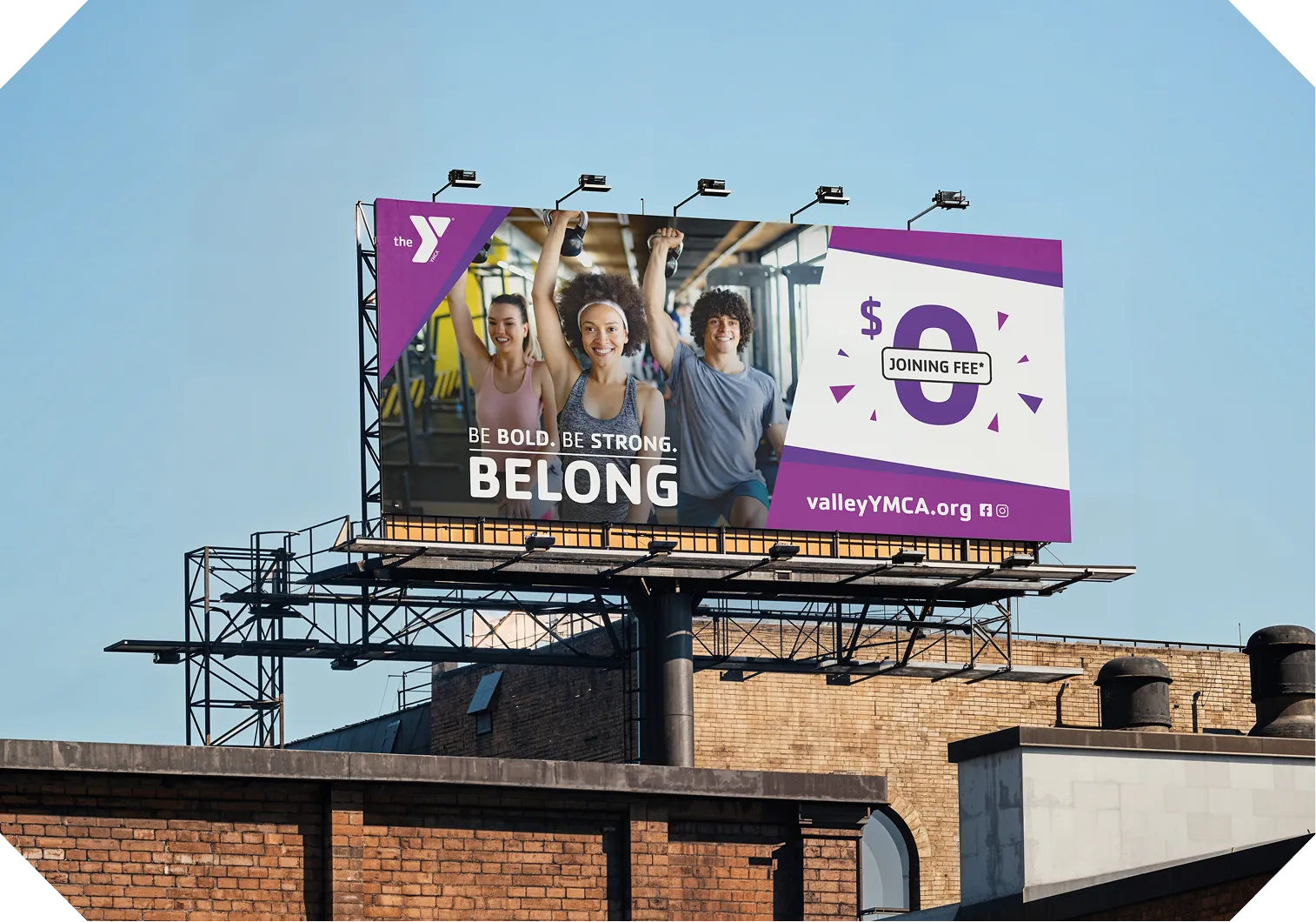 A YMCA "Be Bold. Be Strong. Belong." billboard against a blue sky.