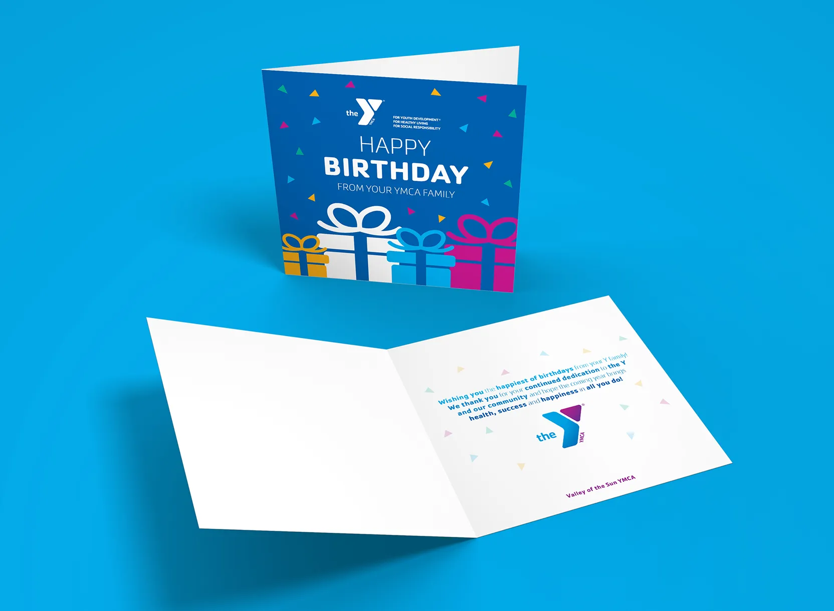 A YMCA birthday greetings card shown open and closed on a blue background.