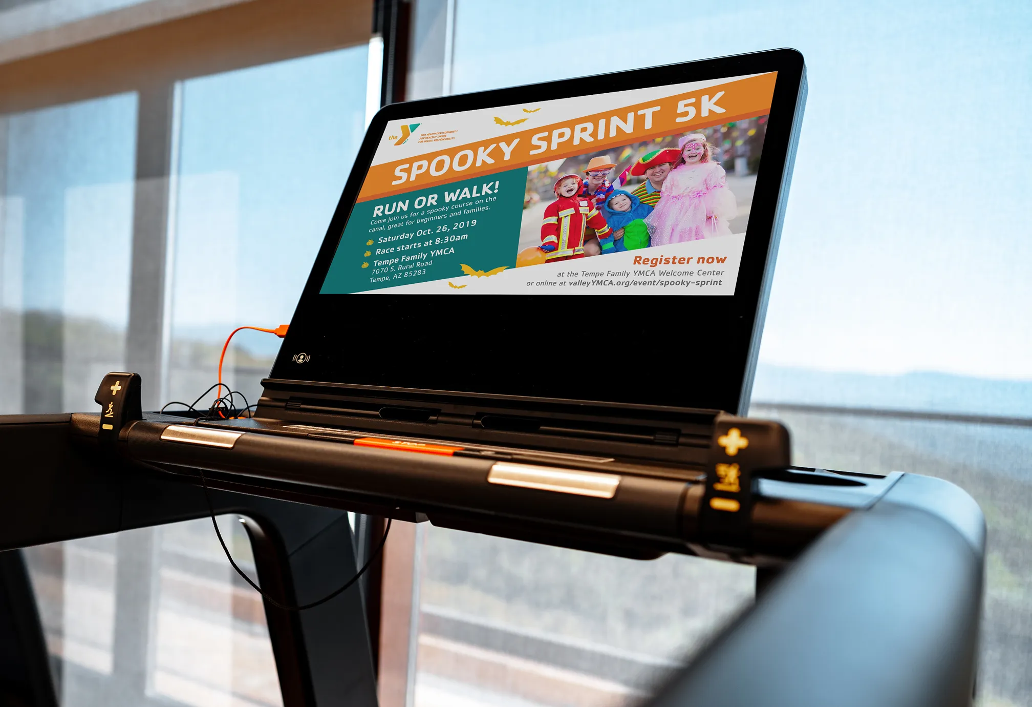 A laptop on a treadmill showing the Spooky Sprint 5K registration page.