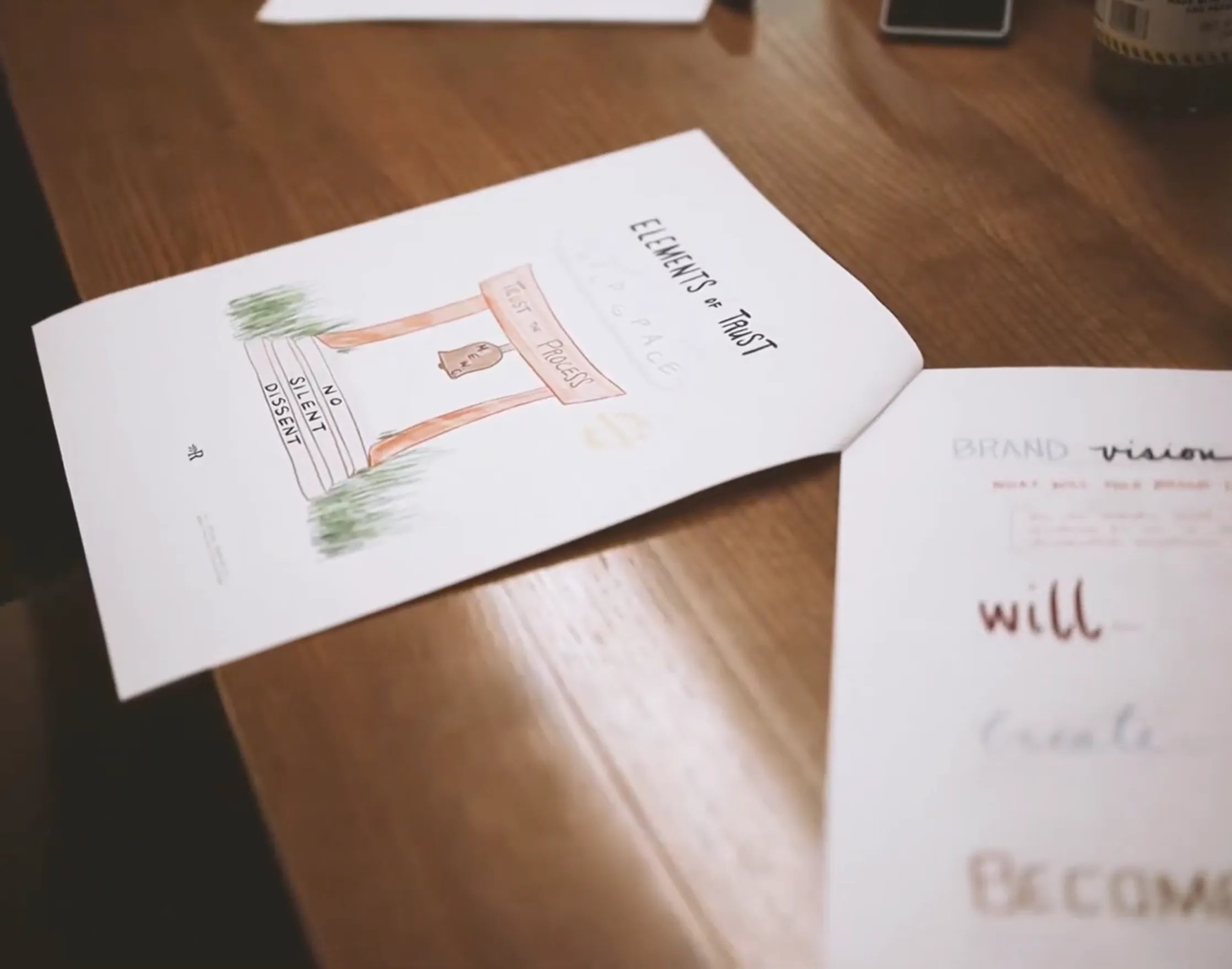 An open notebook on a wooden table with handwritten words in marker.