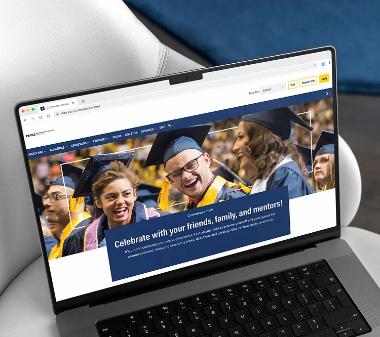 Website page on laptop showing happy graduates in caps and gowns celebrating commencement.
