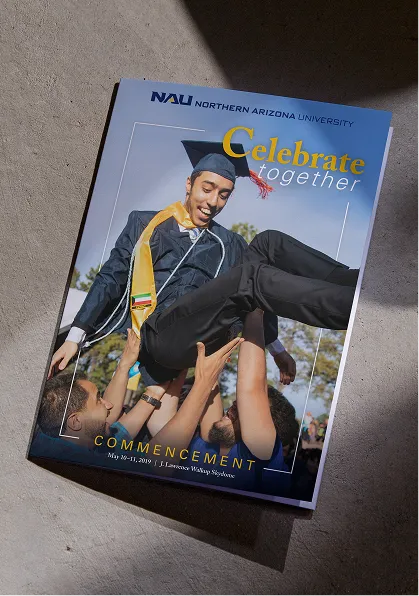 A stack of NAU Passport orientation booklets showing students in cultural attire.