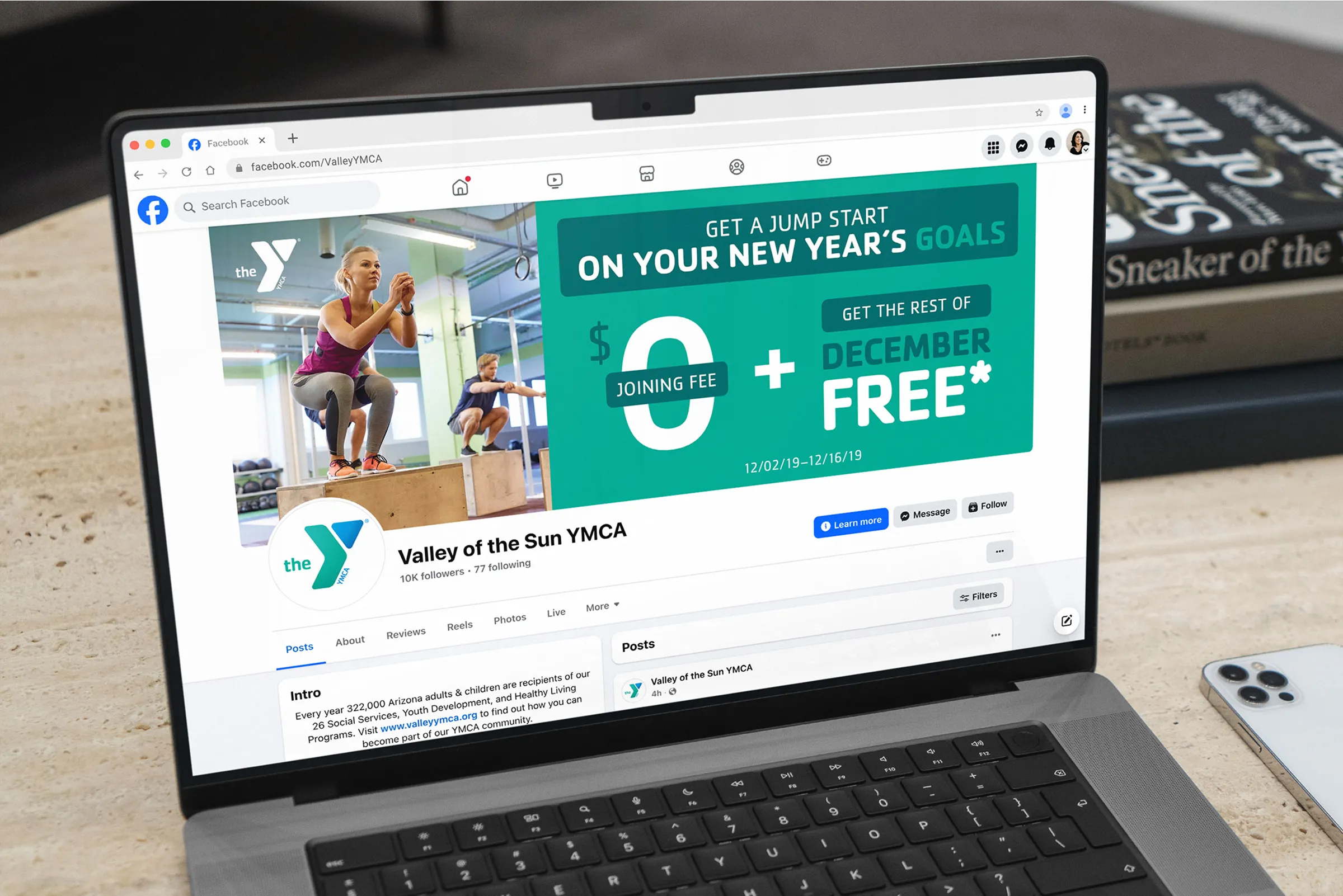 A laptop displaying the Valley of the Sun YMCA site with a New Year's membership offer.