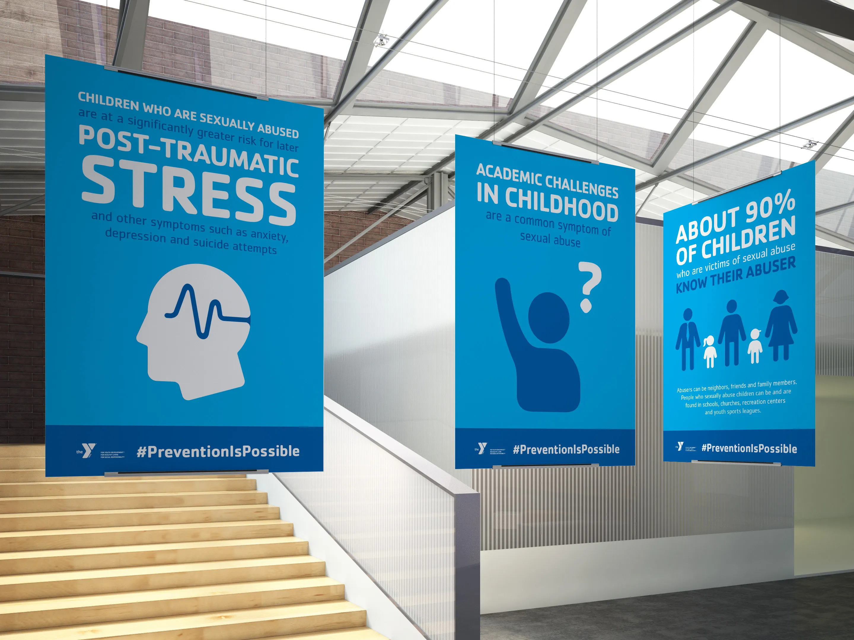 Blue YMCA awareness posters in a stairwell covering post-traumatic stress and academic challenges.