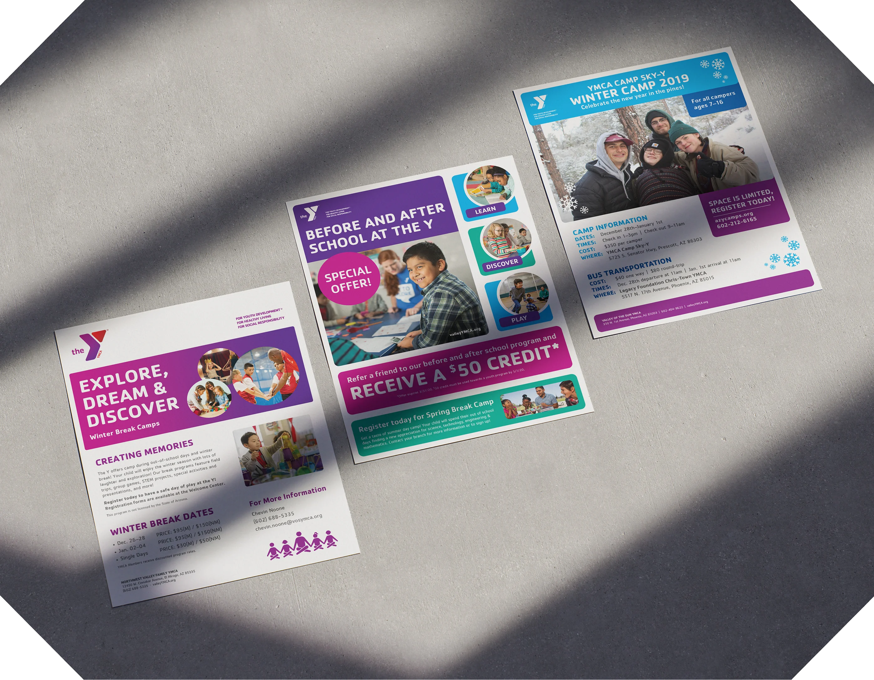 A set of YMCA programme flyers in several colourways arranged on a grey surface.