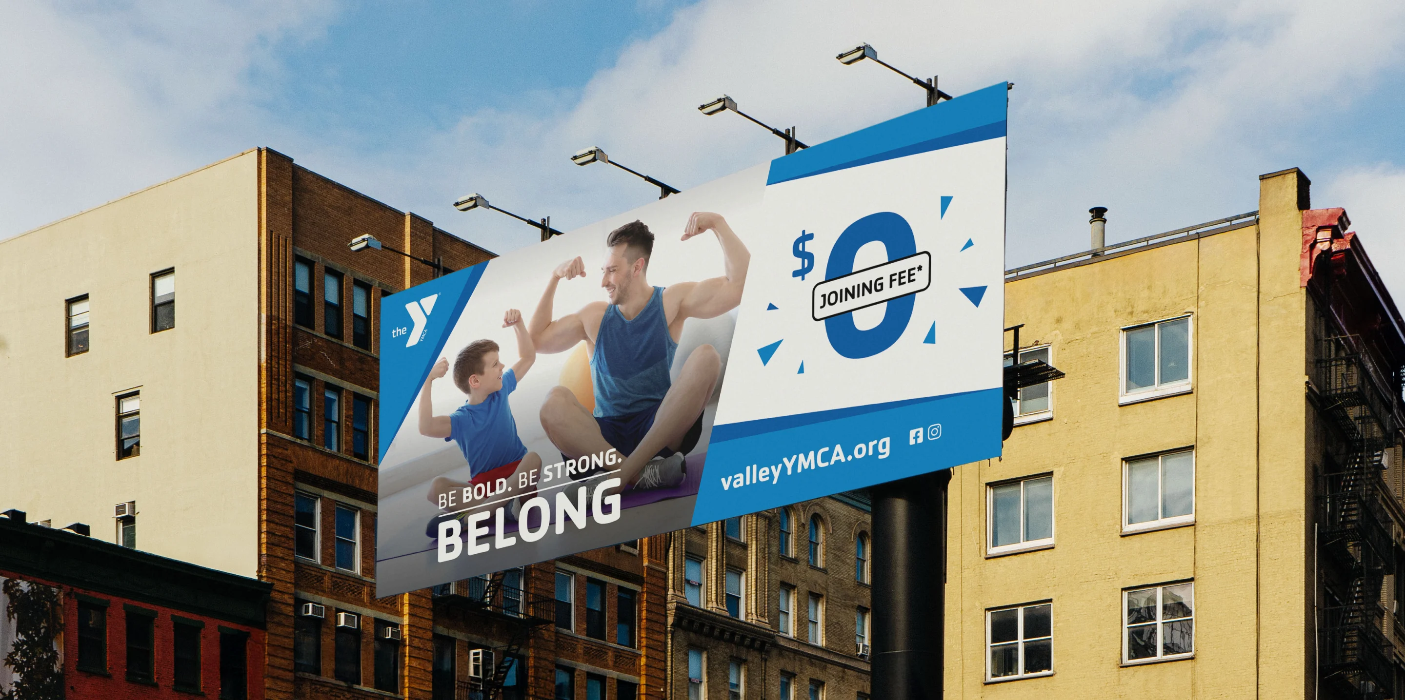 A YMCA "Be Bold. Be Strong. Belong." billboard on a city building advertising a $0 joining fee.