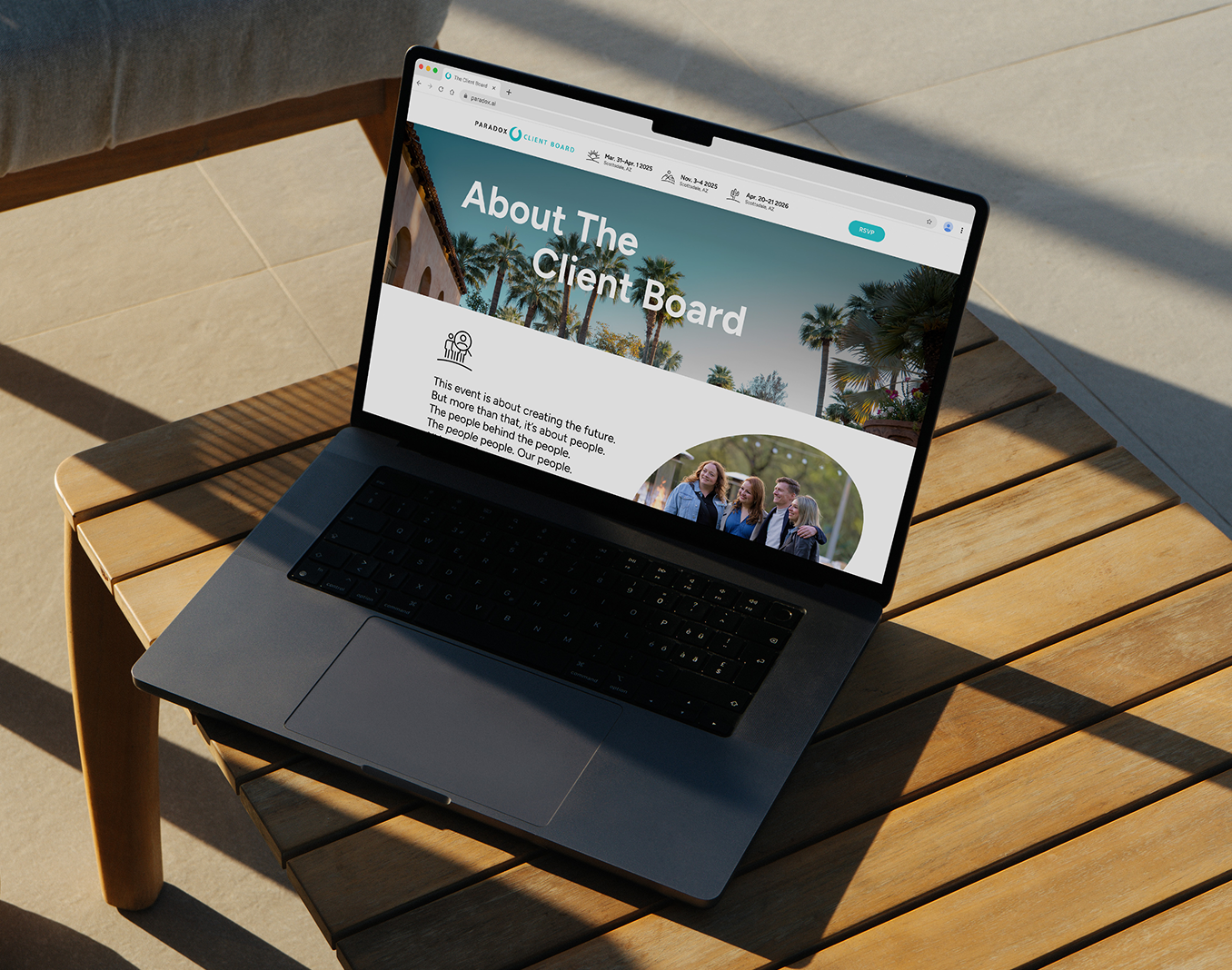 A laptop open on a sunlit wooden outdoor table, displaying the Paradox Client Board "About The Client Board" page.