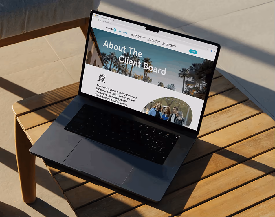 A laptop open on a sunlit wooden outdoor table, displaying the Paradox Client Board "About The Client Board" page.