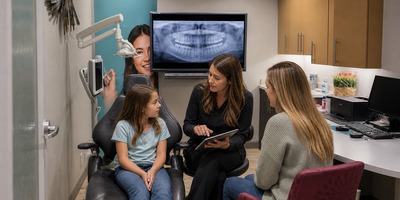 Kendrick Orthodontics team discussing early treatment with a child and parent