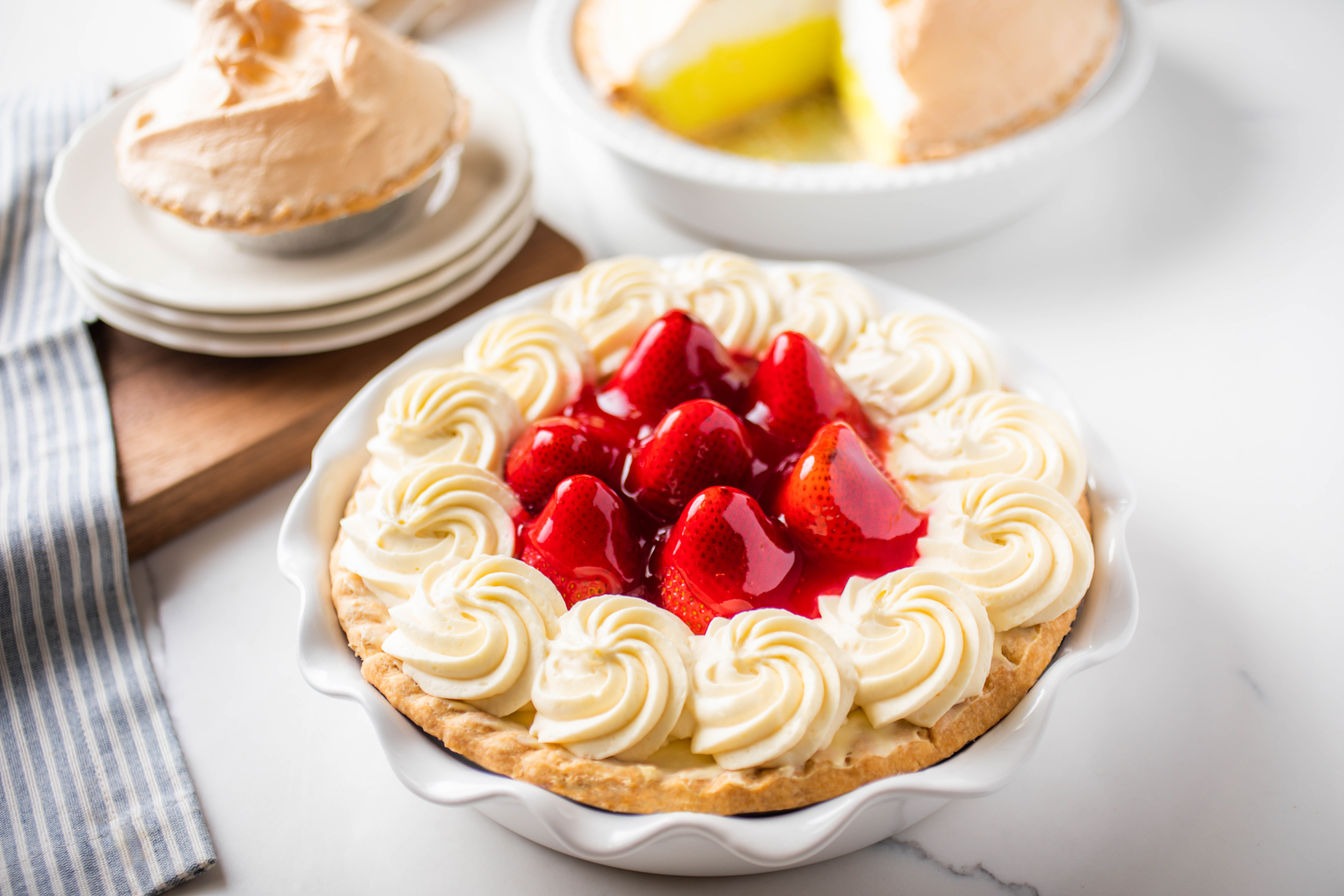 Fresh strawberry cream pie topped with whipped cream and ripe strawberries at Hof's Hut Restaurant & Bakery.