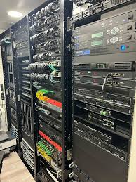 Rows of server racks filled with networking equipment and cables in a data center.
