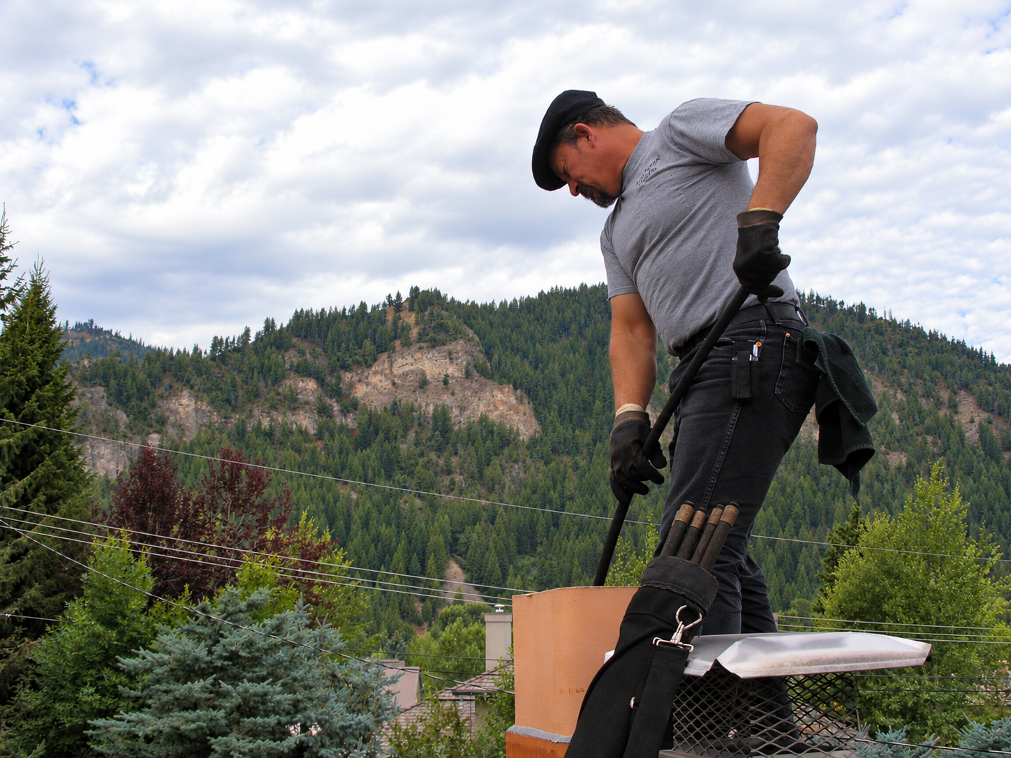 Two Sweeps chimney technician working above a mountain landscape