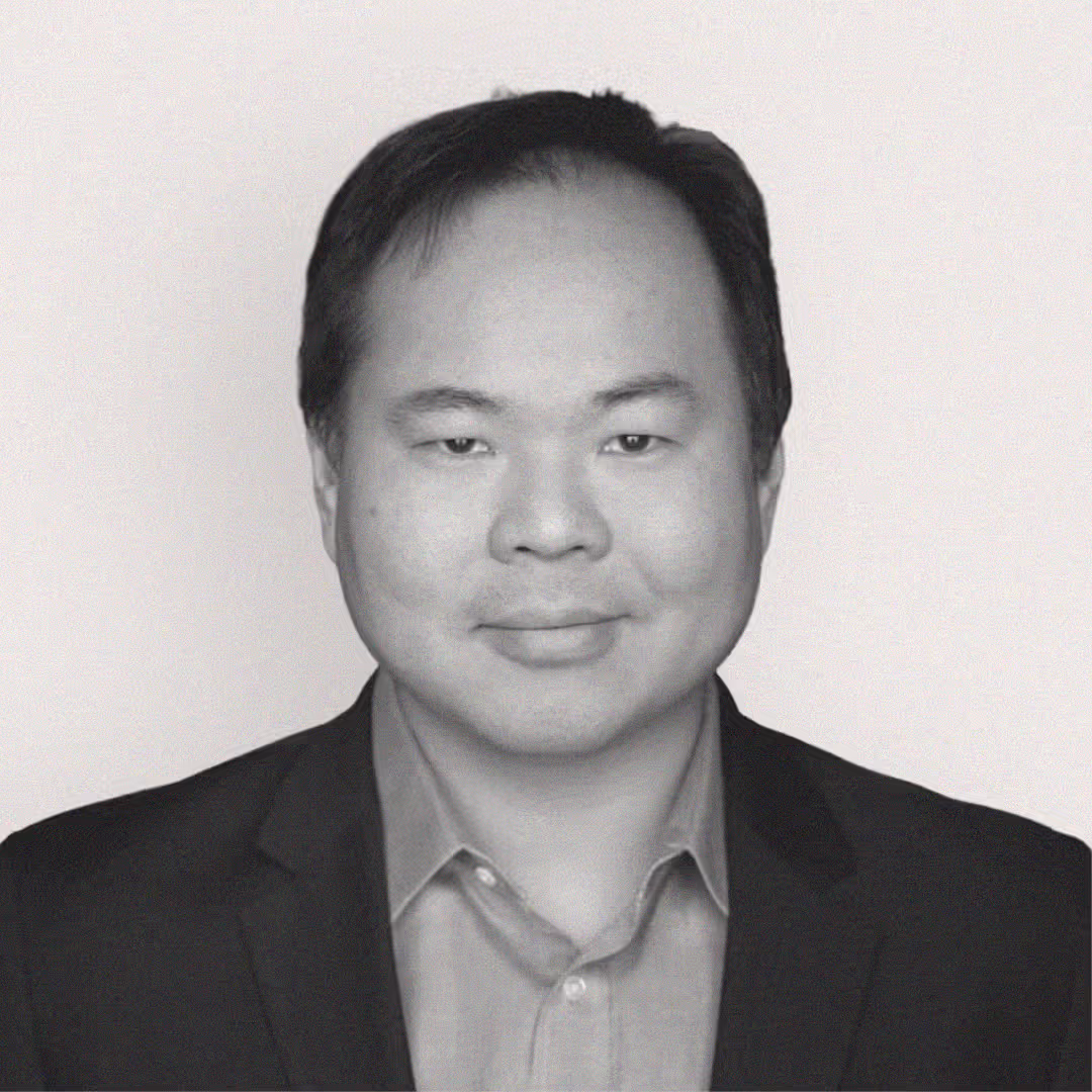 Headshot of John Hu, President at axa·nexa, in a suit jacket and collared shirt against a plain background.