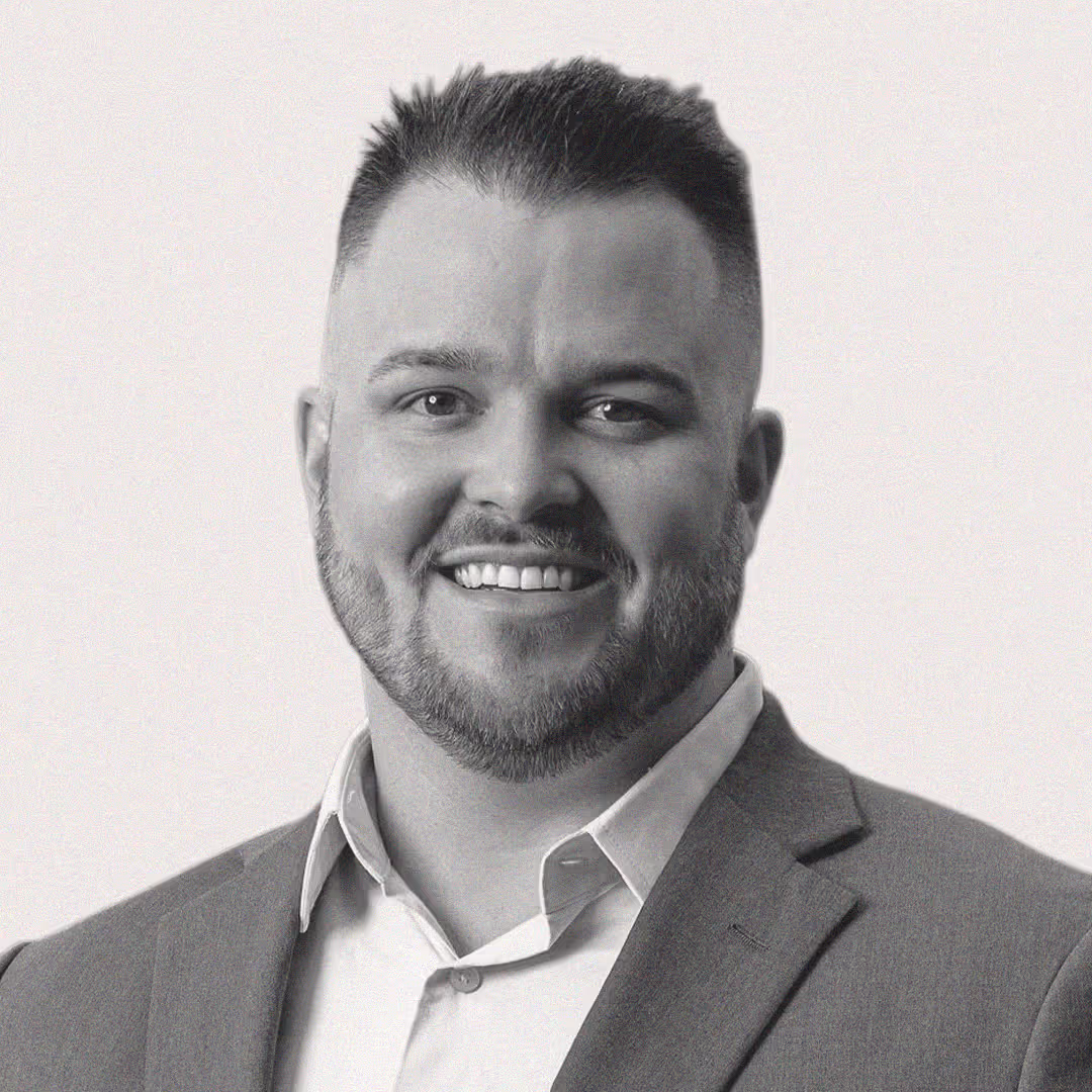 Headshot of Brandon Halverson, VP of Revenue at axa·nexa, smiling with short hair and beard wearing a suit jacket and collared shirt.