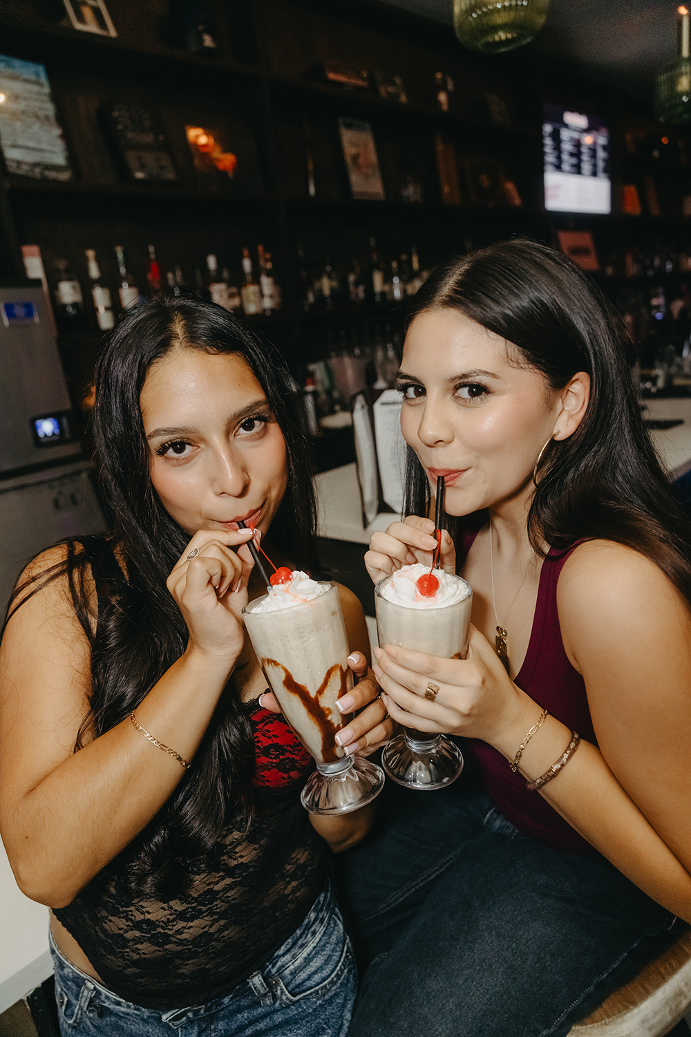 Friends sharing espresso martini milkshakes at sweetest sound during a late night event.