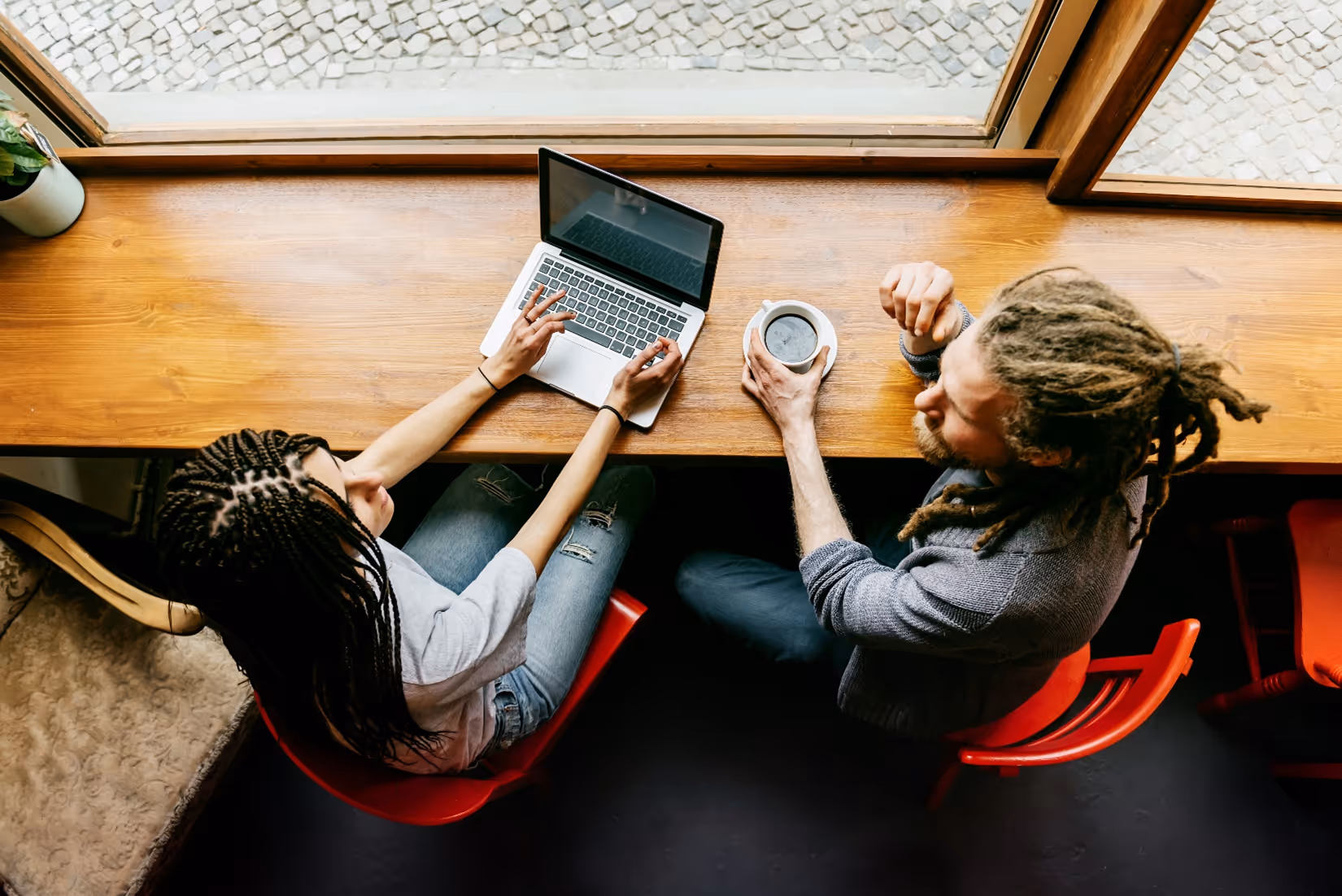 Couple with Laptop drinking coffee displaying tension