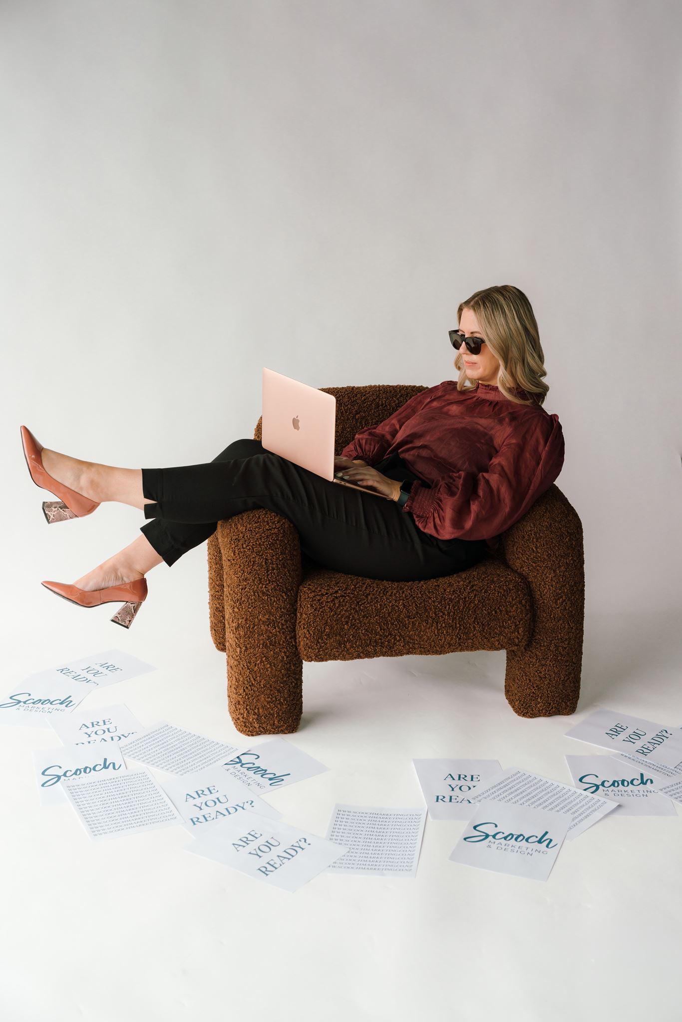 Tam relaxing across a chair working on digital ad campaigns