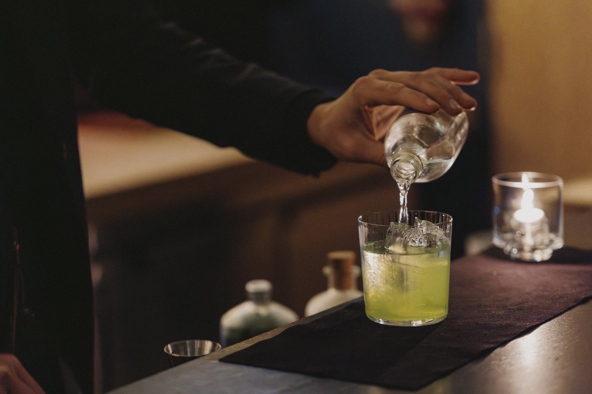 Water poured into a shochu cocktail over hand-cut ice