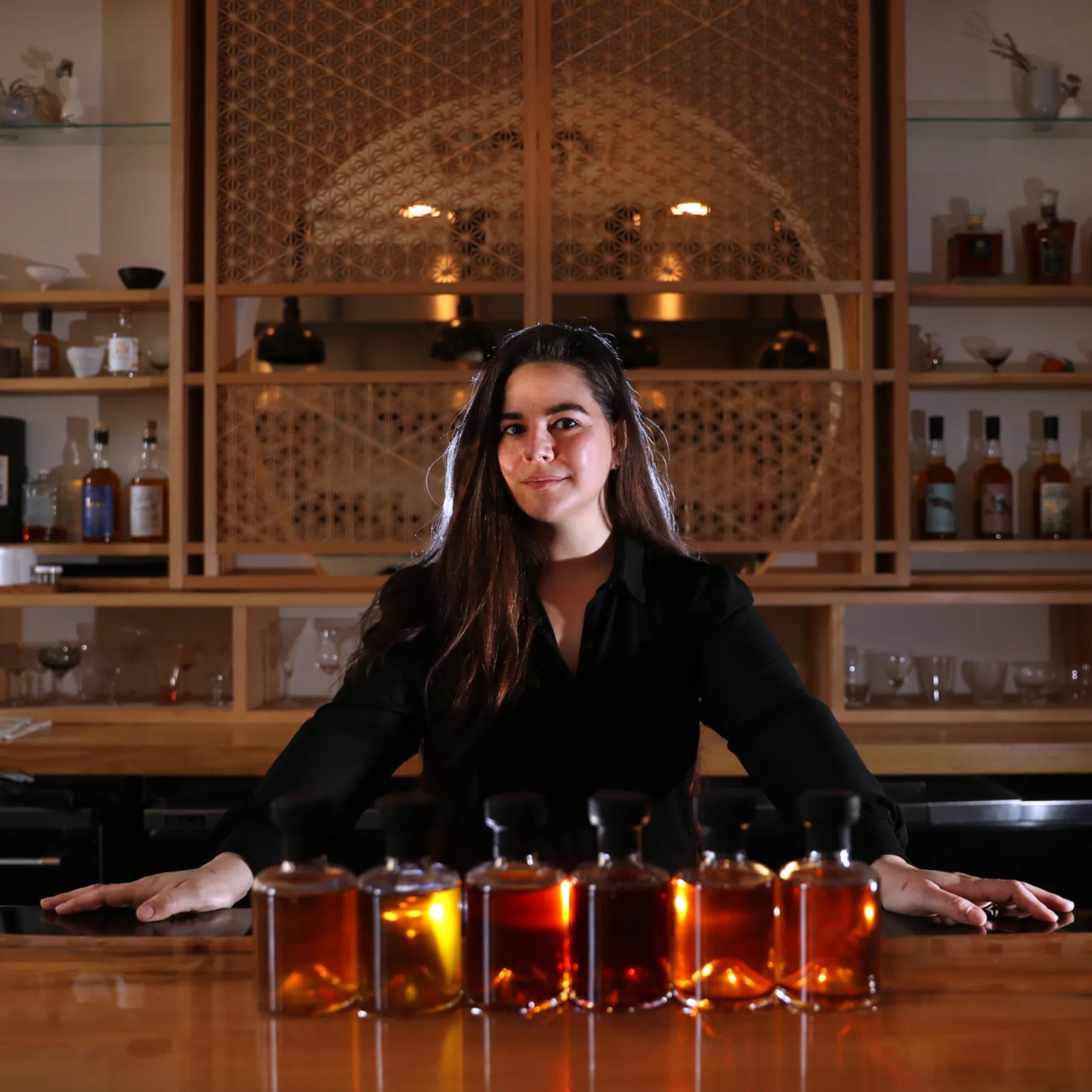 Bottled cocktails lined up along the Kumiko bar, 2020