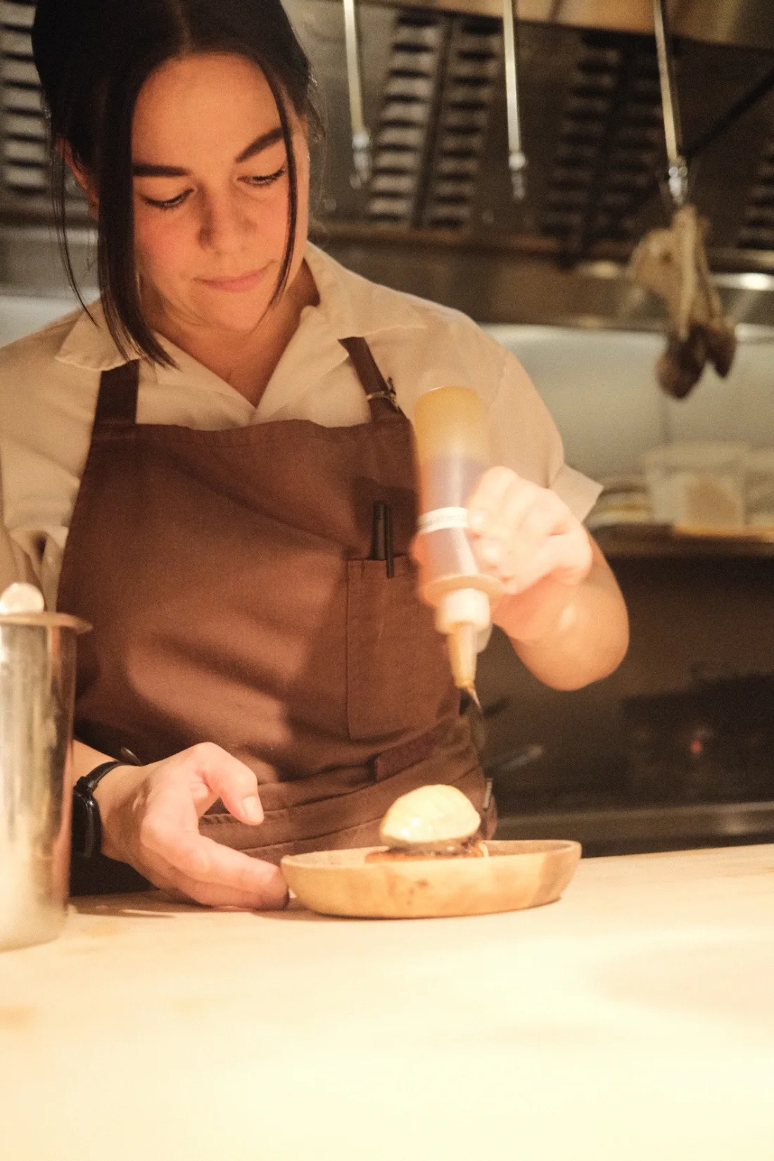 Julia Momosé plating a dish in the Kumiko kitchen