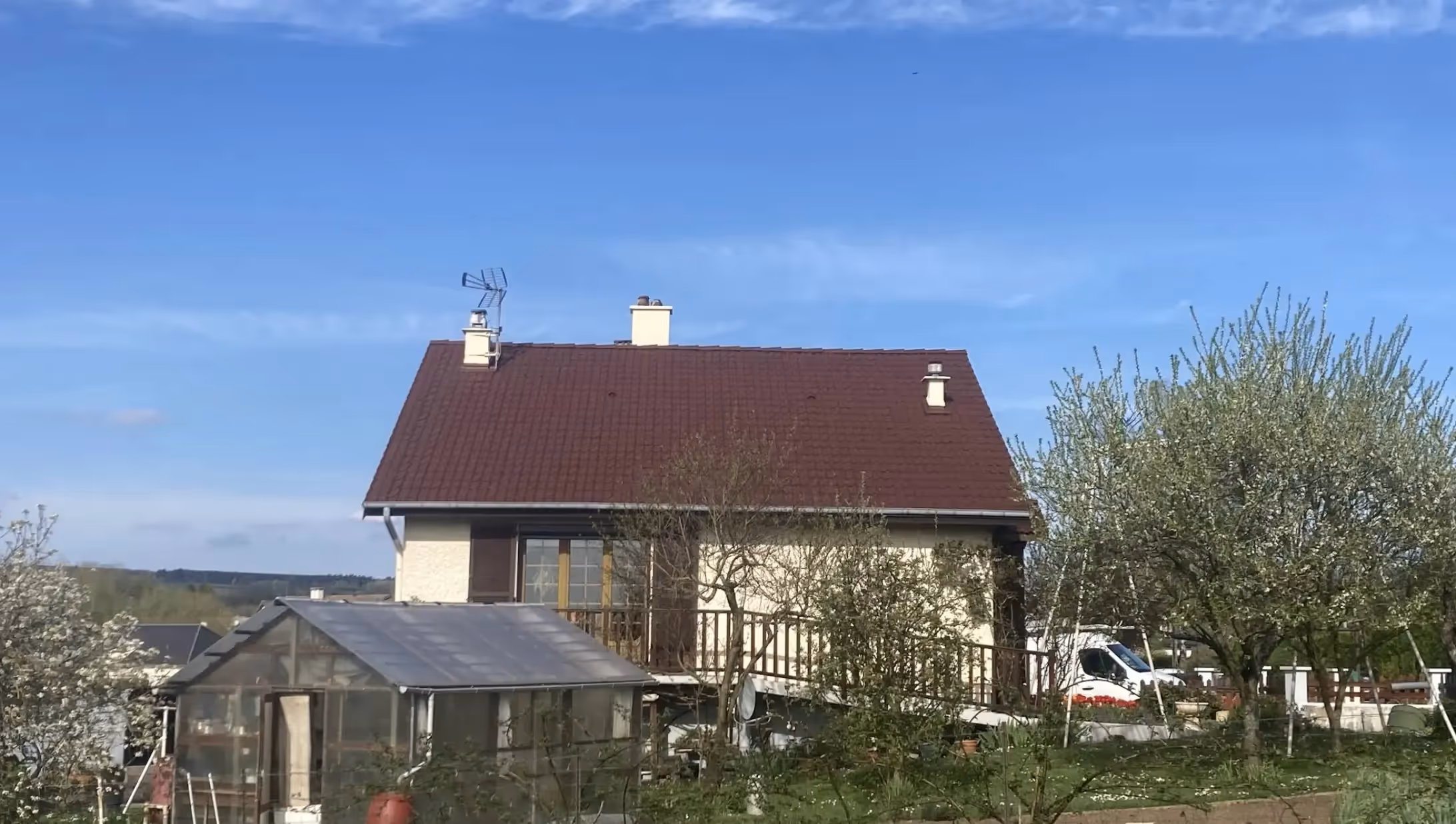 Toiture propre, tuiles uniformément rouges, sans mousse ni traces sombres, temps nuageux.