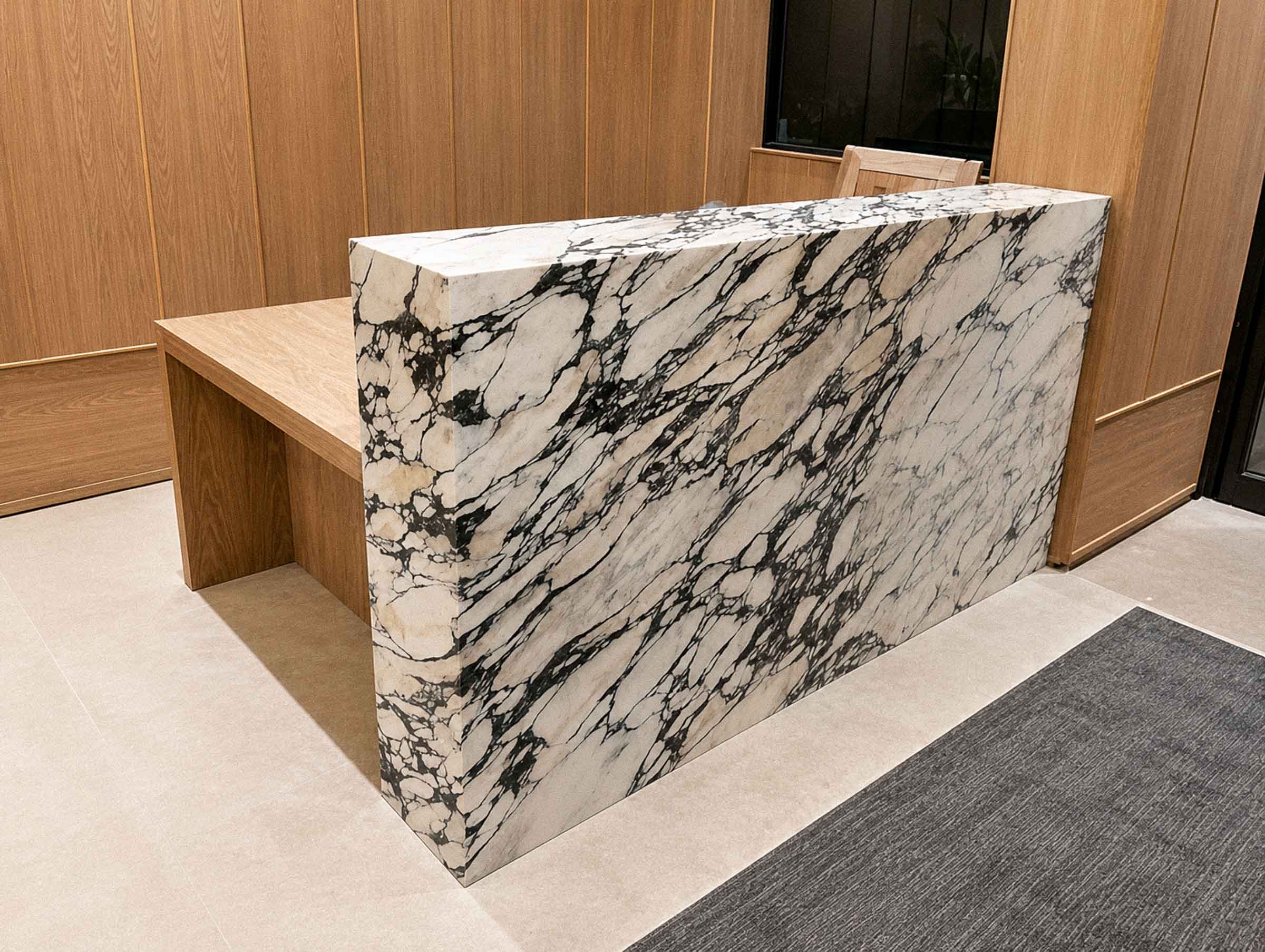 Bespoke marble reception desk handcrafted from natural stone for a commercial interior