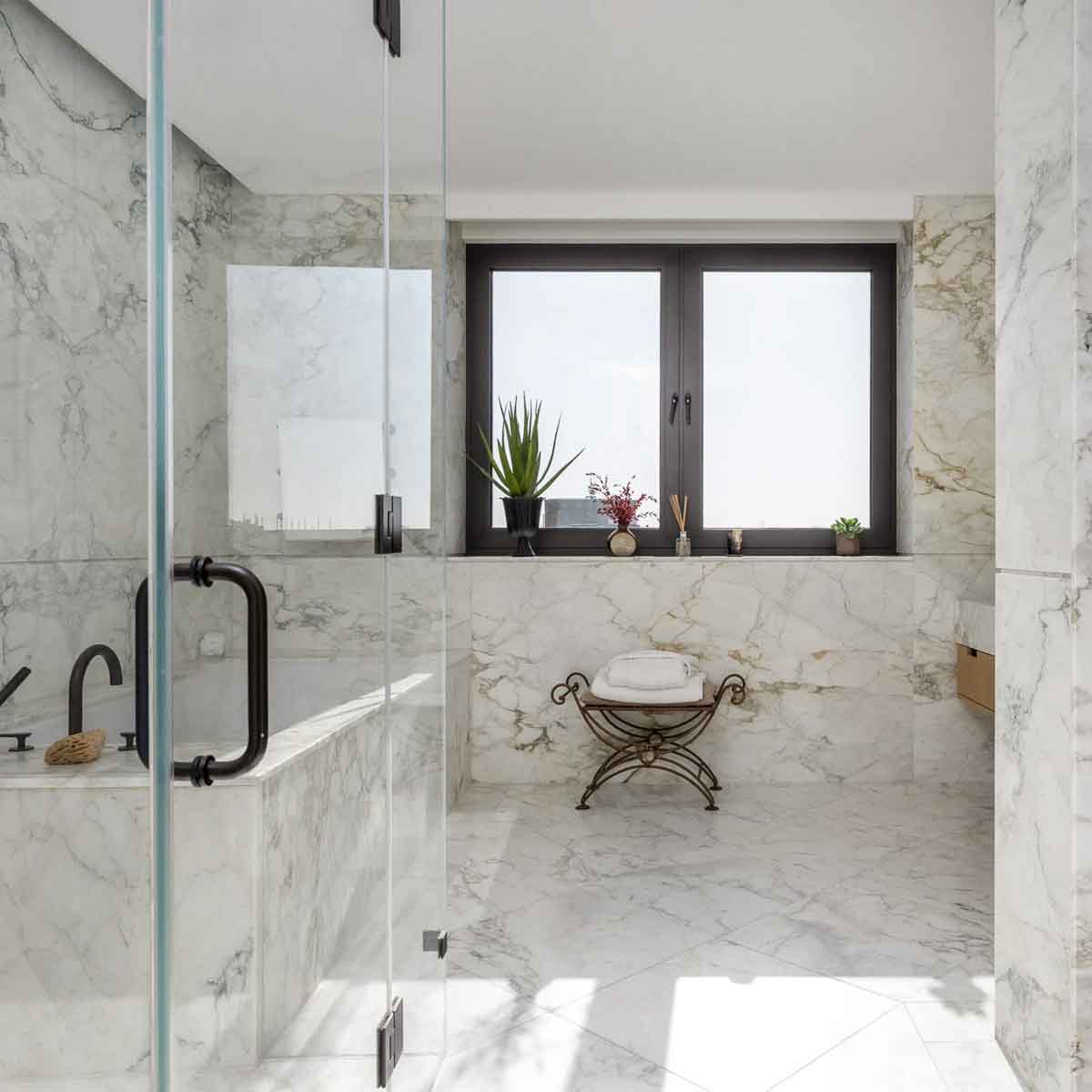Marble bathroom with integrated vanity and floor-to-ceiling stone wall cladding