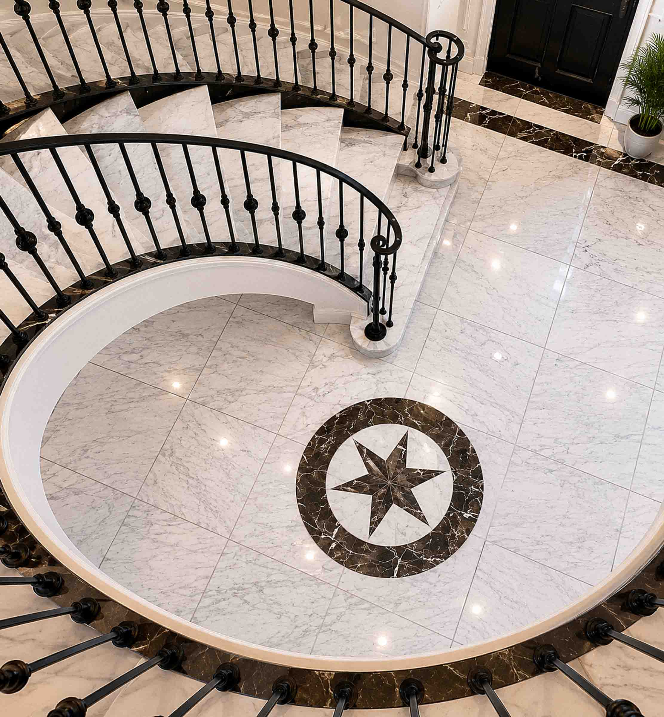Bespoke natural stone staircase with sweeping curved design and handcrafted iron balustrade