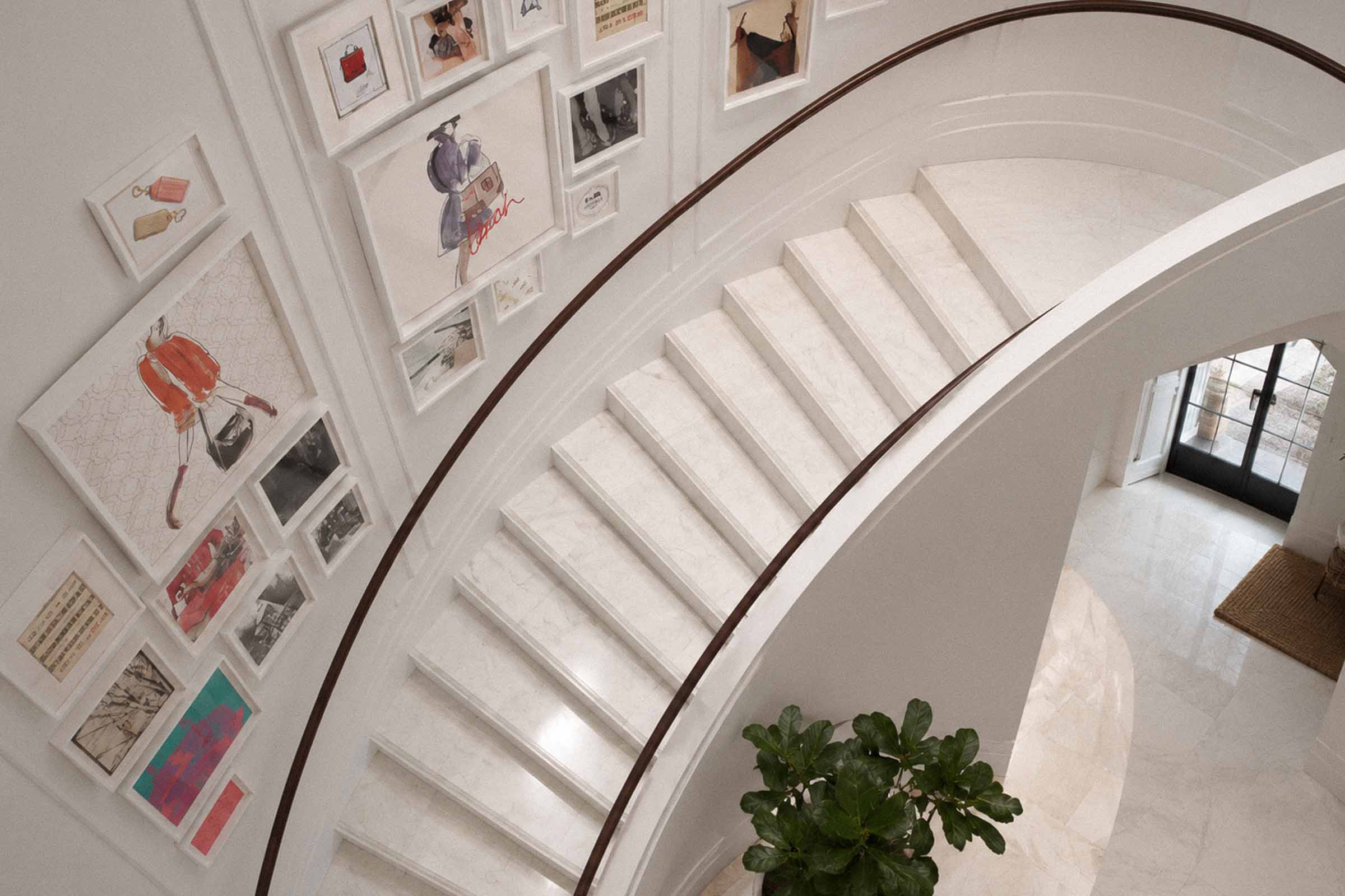 Bespoke natural stone staircase with sweeping curved design and handcrafted iron balustrade