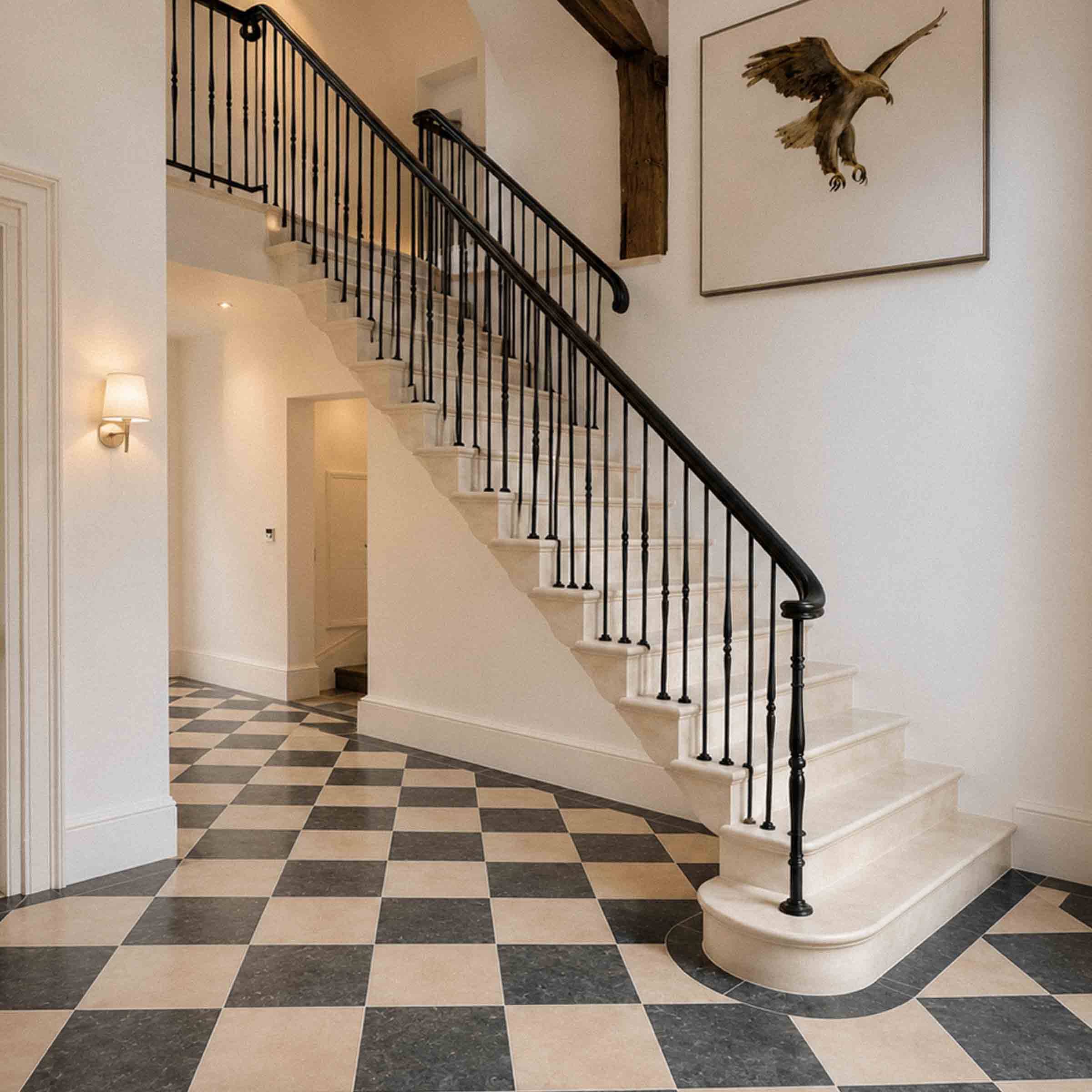 Bespoke natural stone staircase with sweeping curved design and handcrafted iron balustrade