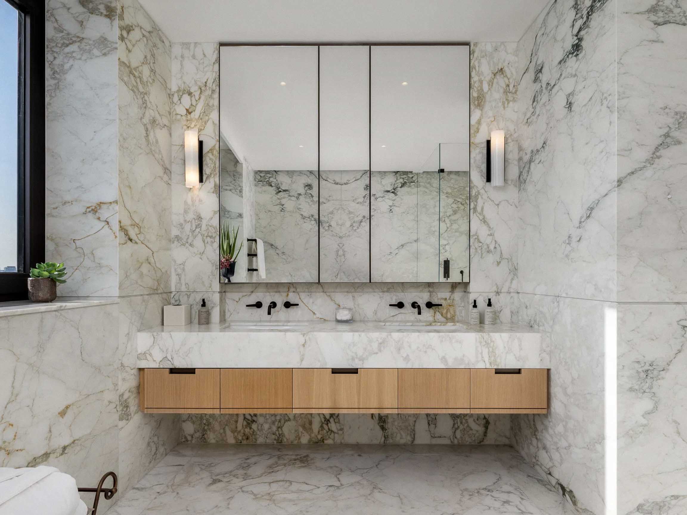 Marble bathroom with integrated vanity and floor-to-ceiling stone wall cladding