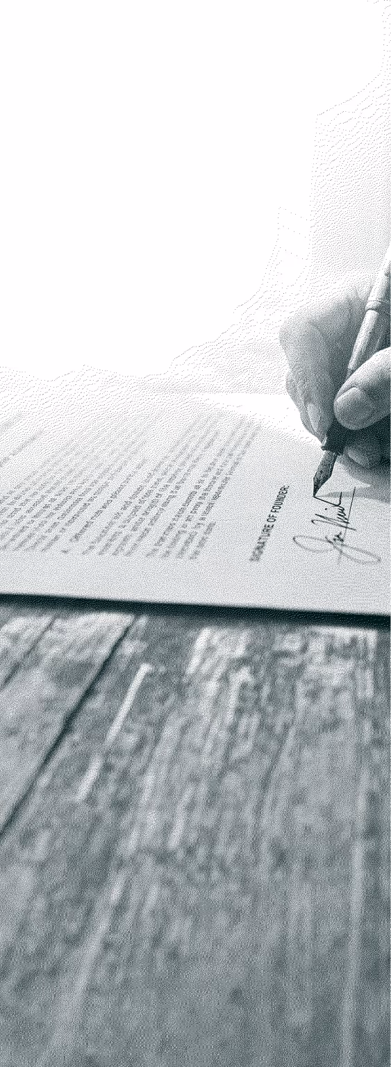 Hand signing a document labeled Signature of Founder on a textured wooden surface.