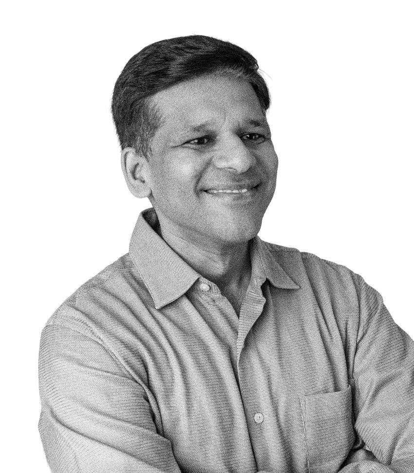 Smiling man with short hair in a collared shirt with arms crossed, facing slightly right.