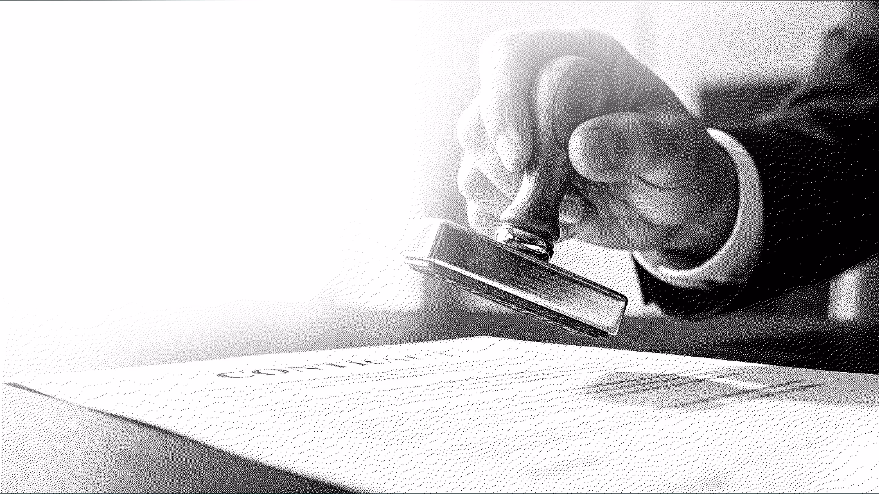Hand holding a wood stamp pressing down on a document on a desk.