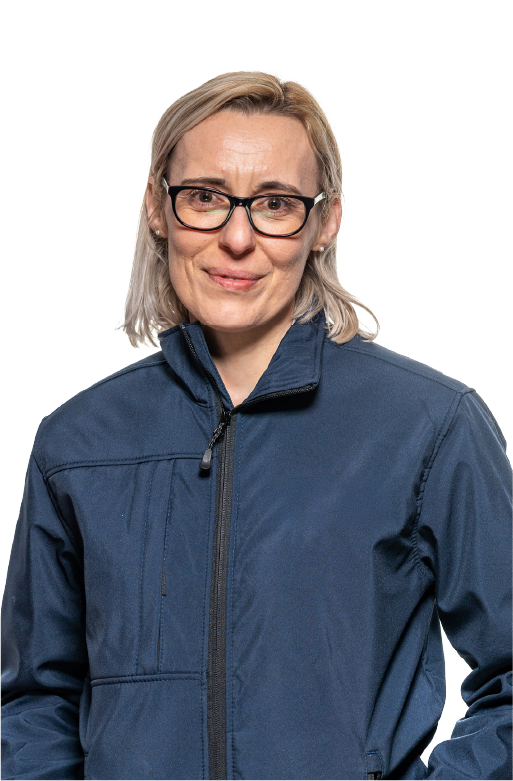 Smiling middle-aged woman with light blond hair wearing black glasses and a dark blue zip-up jacket against a white background.