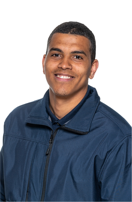 Smiling young man with short hair wearing a dark blue zip-up jacket and a dark shirt underneath.