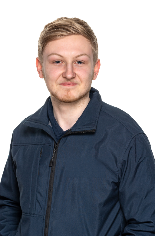 Young man with blonde hair and light facial hair wearing a navy jacket and smiling slightly against a white background.