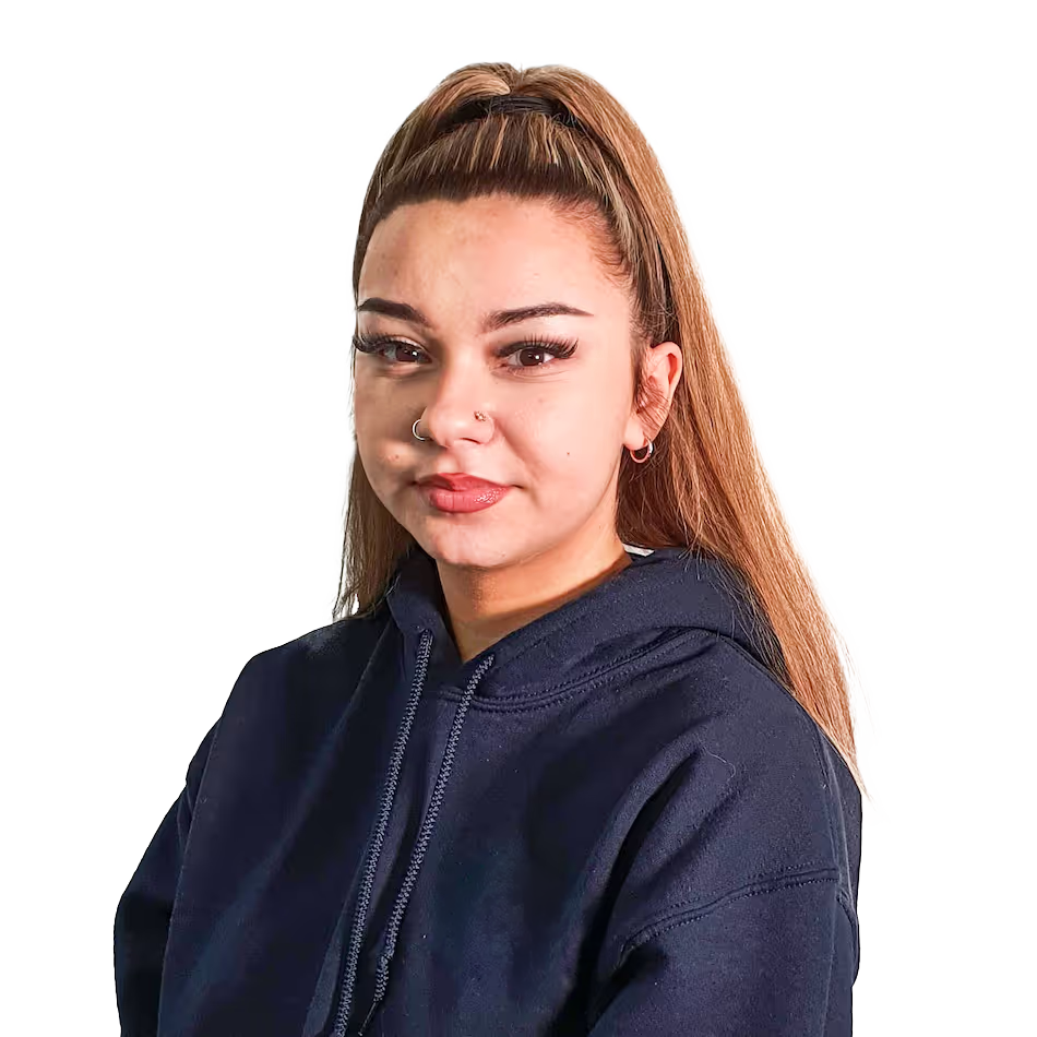 Young woman with long light brown hair tied in a high ponytail, wearing a dark hoodie, with nose rings and hoop earrings, against a white background.