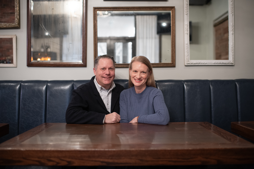 A man and woman sitting at a table in a restaurant.