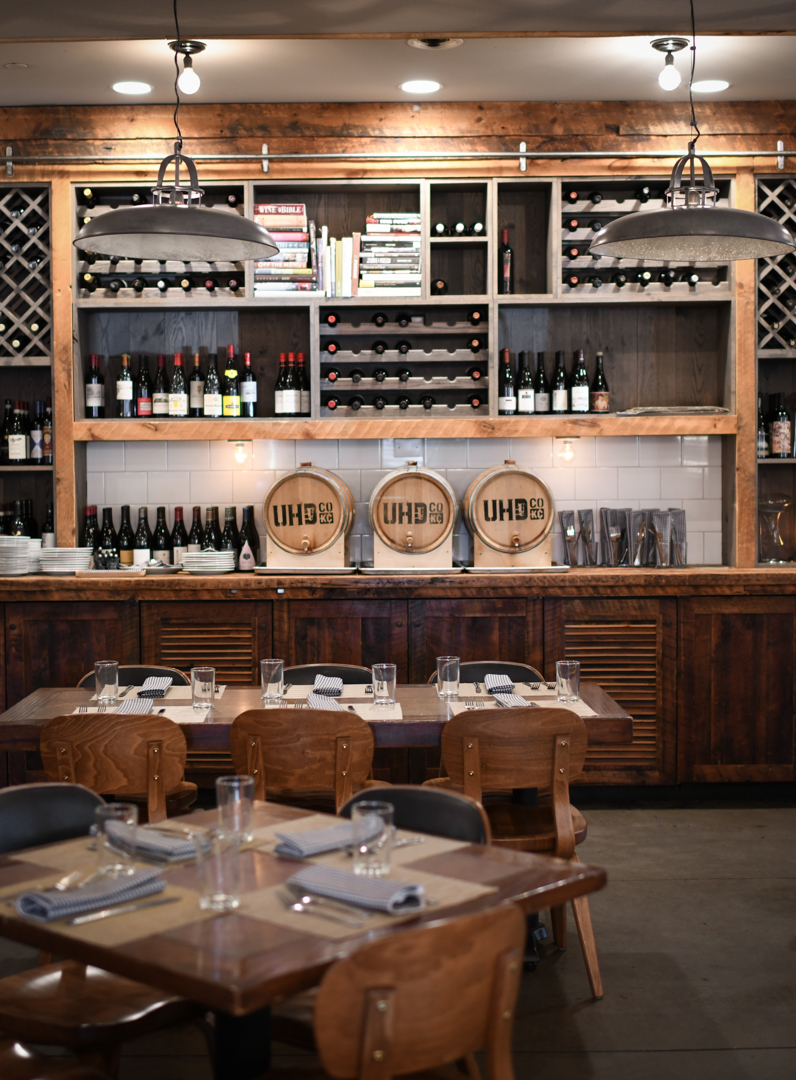 A restaurant with a wooden bar and a wine rack.