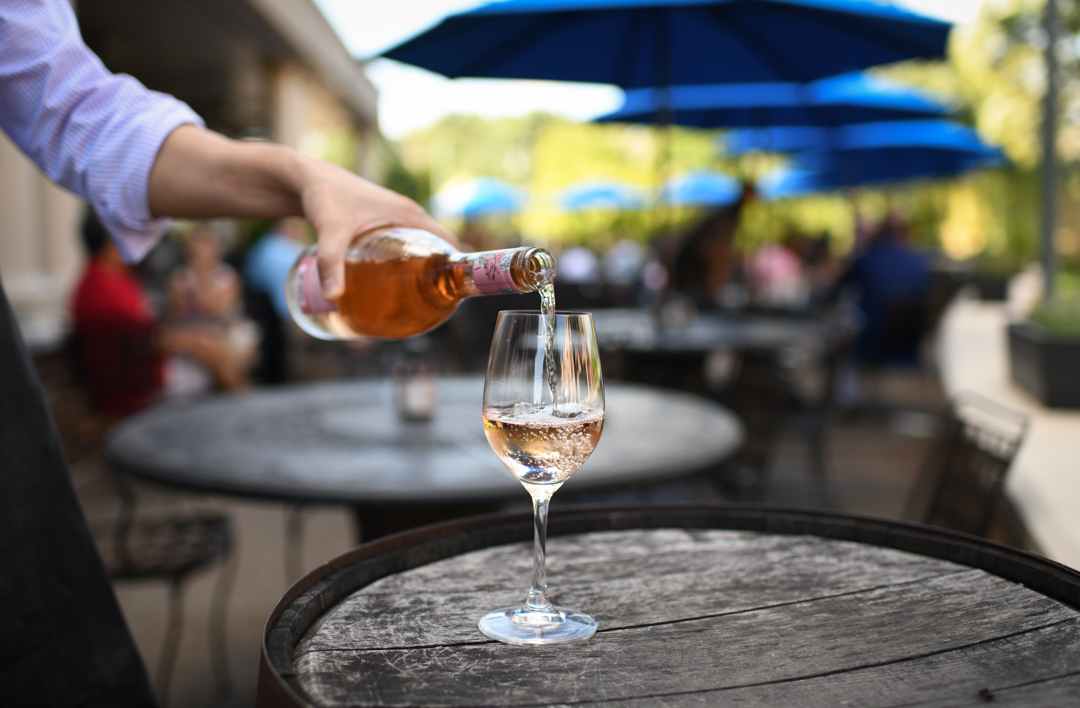 A man pouring wine into a glass.
