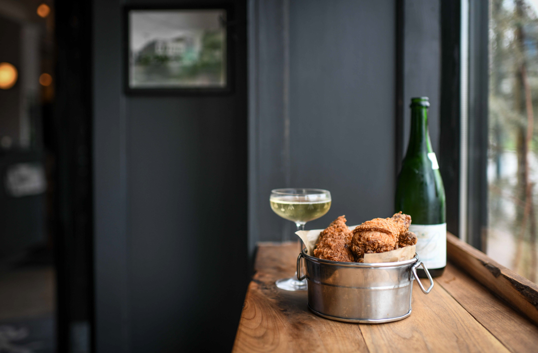 A bottle of wine and a glass of wine on a table.