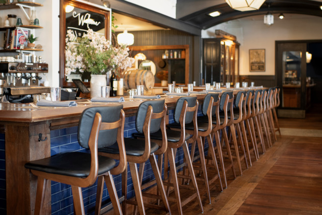 A bar with a wooden counter and stools.