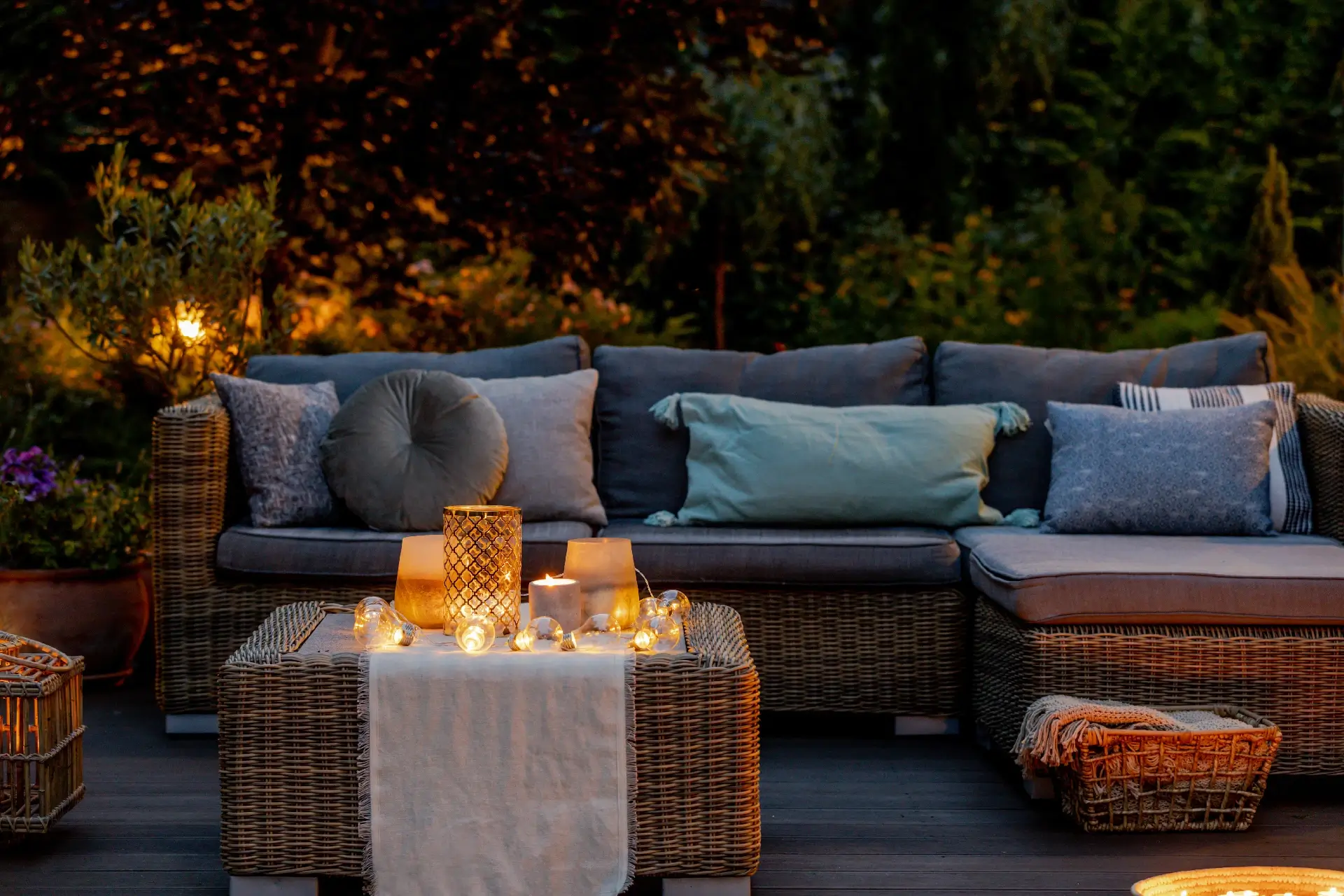 Warm summer night in the garden with trendy furniture, lights, lanterns and candles