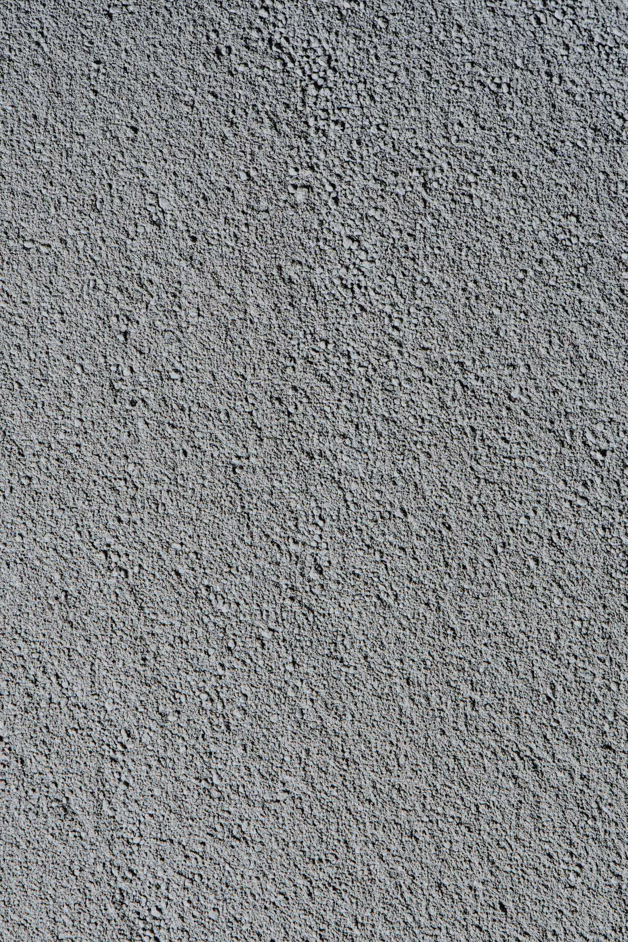 Grobe, körnige graue Betonoberfläche mit unregelmäßiger Textur.