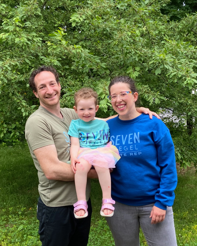 Seven Siegel with their wife Becky Wartell and their young daughter, all smiling outdoors in Seven Siegel campaign shirts