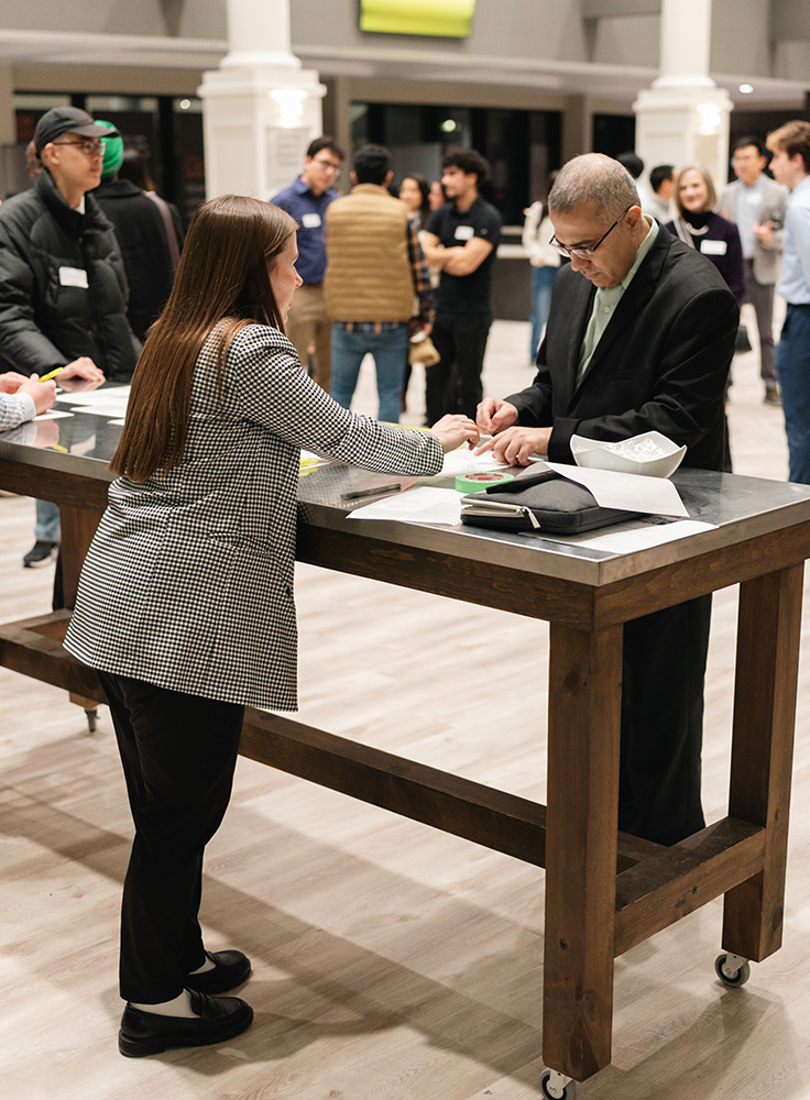 People engaging and registering at a networking event in a bright indoor space.