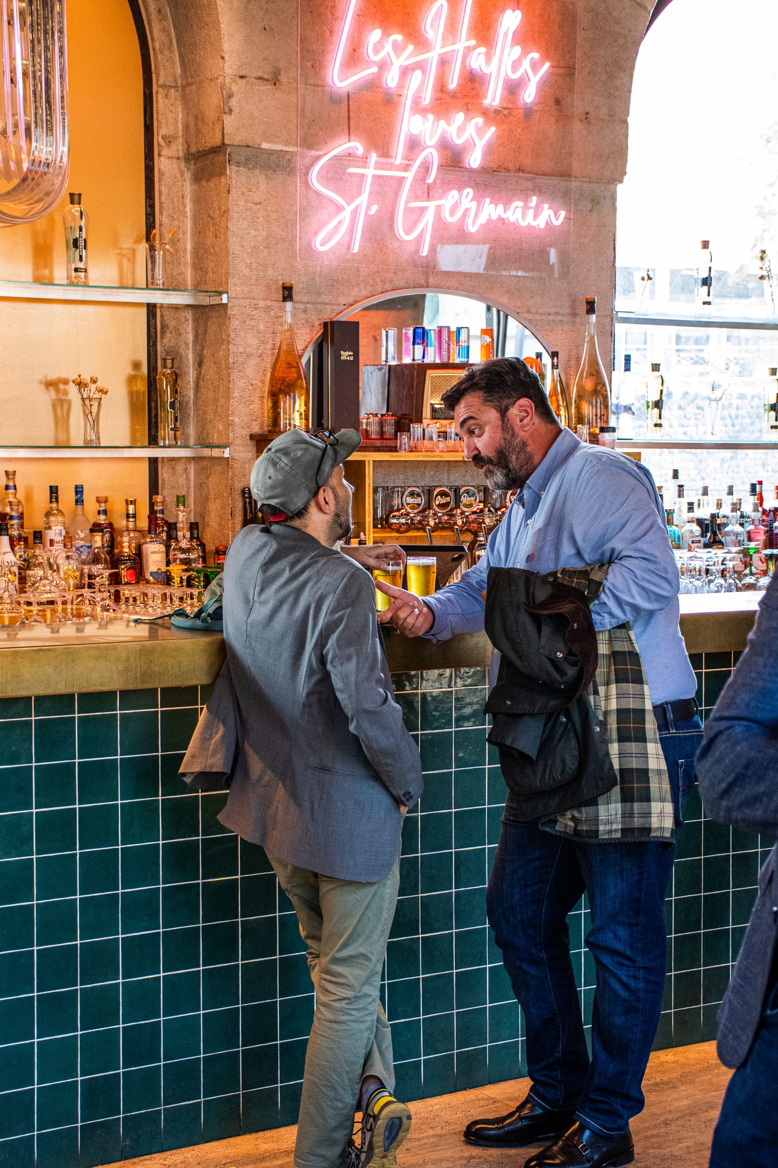 Guests networking at corporate event with neon bar sign in background